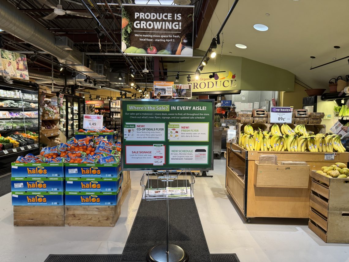Photo of produce section with sign announcing changes