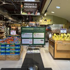 Photo of produce section with sign announcing changes