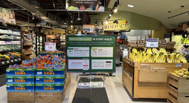 Photo of produce section with sign announcing changes